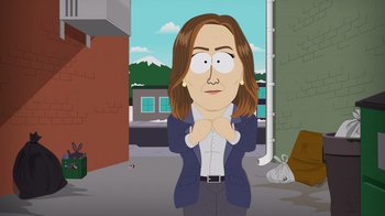 Movie still from “South Park: Joining the Panderverse” (2023), directed by Trey Parker – A woman in a business suit standing in front of a brick building; Medium shot, Over the shoulder angle