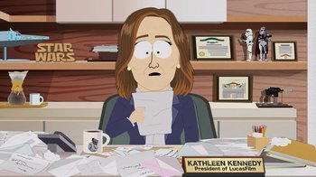 Movie still from “South Park: Joining the Panderverse” (2023), directed by Trey Parker – A woman sitting at a desk holding a piece of paper; Medium shot, Over the shoulder angle