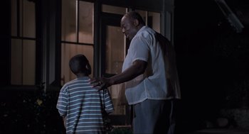 Movie still from “Space Jam” (1996), directed by Joe Pytka – An older man and a young boy standing next to each other; Medium shot, Low angle