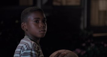 Movie still from “Space Jam” (1996), directed by Joe Pytka – A young boy holding a basketball in his hands; Close Up shot, Over the shoulder angle