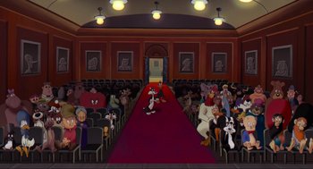 Movie still from “Space Jam” (1996), directed by Joe Pytka – A group of people sitting on a red carpet in front of a crowd; Wide shot, High angle