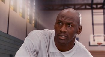 Movie still from “Space Jam” (1996), directed by Joe Pytka – A person wearing a white shirt; Close Up shot, Over the shoulder angle
