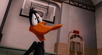 Movie still from “Space Jam” (1996), directed by Joe Pytka – A cartoon character with an orange head and a black beak; Close Up shot, High angle