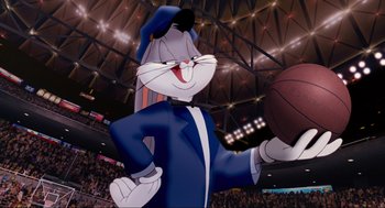 Movie still from “Space Jam” (1996), directed by Joe Pytka – A cartoon character is holding a basketball in front of an audience; Medium shot, Low angle