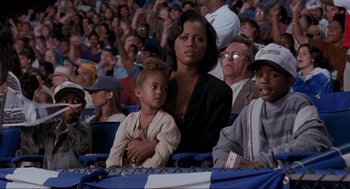 Movie still from “Space Jam” (1996), directed by Joe Pytka – A woman and a little girl are sitting in a crowd; Medium shot, Over the shoulder angle