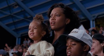 Movie still from “Space Jam” (1996), directed by Joe Pytka – A woman and two children are watching a game; Medium shot, Low angle