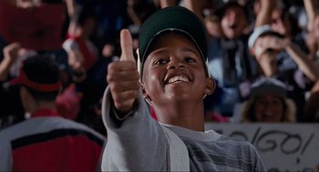 Movie still from “Space Jam” (1996), directed by Joe Pytka – A young boy giving a thumbs up in front of a crowd; Close Up shot, Low angle