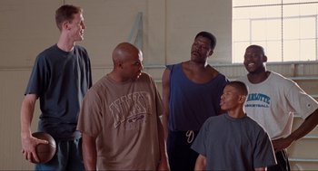 Movie still from “Space Jam” (1996), directed by Joe Pytka – A group of men standing in a room together; Medium shot, Low angle