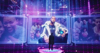 Movie still from “Space Jam: A New Legacy” (2021), directed by Malcolm D. Lee – A man standing in front of a large picture of a man; Extreme Wide shot, Over the shoulder angle