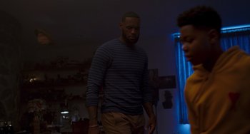 Movie still from “Space Jam: A New Legacy” (2021), directed by Malcolm D. Lee – A man standing in a living room next to a woman; Medium shot, Over the shoulder angle