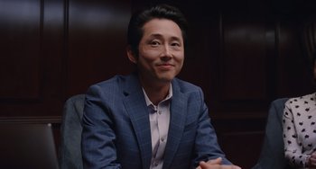 Movie still from “Space Jam: A New Legacy” (2021), directed by Malcolm D. Lee – A man in a suit sitting in front of a wooden wall; Close Up shot, Over the shoulder angle