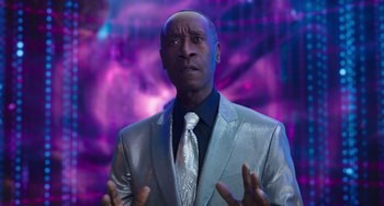 Movie still from “Space Jam: A New Legacy” (2021), directed by Malcolm D. Lee – A man in a silver suit and a white tie; Close Up shot, Low angle