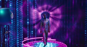 Movie still from “Space Jam: A New Legacy” (2021), directed by Malcolm D. Lee – A man in a suit and tie walking on a stage; Wide shot, Low angle