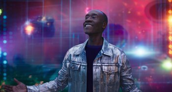 Movie still from “Space Jam: A New Legacy” (2021), directed by Malcolm D. Lee – A man in a silver jacket smiling at the camera; Medium shot, Low angle