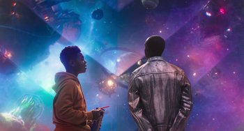 Movie still from “Space Jam: A New Legacy” (2021), directed by Malcolm D. Lee – Two men are standing in front of a space background; Medium shot, Low angle