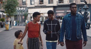 Movie still from “Space Jam: A New Legacy” (2021), directed by Malcolm D. Lee – A group of people walking down a street; Medium shot, Over the shoulder angle