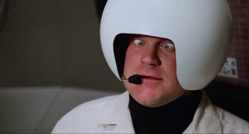 Movie still from “Spaceballs” (1987), directed by Mel Brooks – A man wearing a helmet with a microphone in his mouth; Close Up shot, High angle