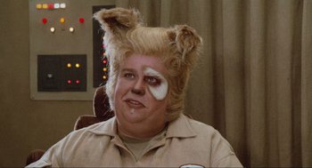 Movie still from “Spaceballs” (1987), directed by Mel Brooks – A man with a blonde wig and makeup on his face; Close Up shot, Low angle