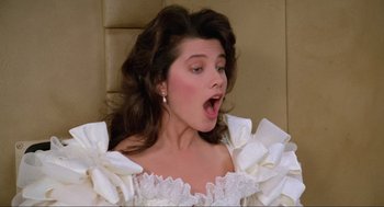 Movie still from “Spaceballs” (1987), directed by Mel Brooks – A woman in a white dress is making a funny face; Close Up shot, Low angle
