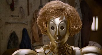 Movie still from “Spaceballs” (1987), directed by Mel Brooks – A gold robot with a brown hair wig; Close Up shot, High angle