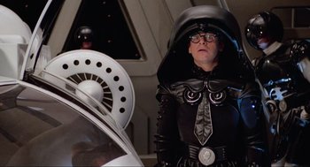 Movie still from “Spaceballs” (1987), directed by Mel Brooks – A woman in a black outfit and a black hat; Medium shot, Low angle