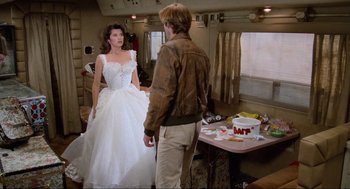 Movie still from “Spaceballs” (1987), directed by Mel Brooks – A woman in a white dress and a man in a brown leather jacket; Wide shot, Over the shoulder angle