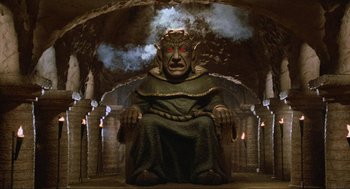 Movie still from “Spaceballs” (1987), directed by Mel Brooks – An image of a statue of an elf sitting in a cave; Wide shot, Low angle
