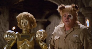 Movie still from “Spaceballs” (1987), directed by Mel Brooks – A man in a bear costume next to a woman in a gold robot costume; Close Up shot, Low angle