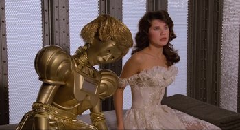 Movie still from “Spaceballs” (1987), directed by Mel Brooks – A woman in a white dress and a man in a gold suit; Medium shot, Low angle