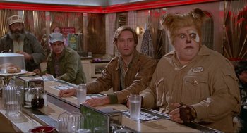 Movie still from “Spaceballs” (1987), directed by Mel Brooks – A group of people sitting at a table in a restaurant; Medium shot, Over the shoulder angle