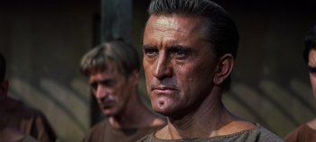 Movie still from “Spartacus” (1960), directed by Stanley Kubrick – A man in a brown shirt and another man in a brown shirt; Close Up shot, Low angle