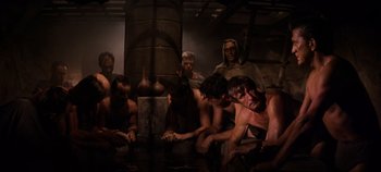 Movie still from “Spartacus” (1960), directed by Stanley Kubrick – A group of men sitting next to each other in a room; Wide shot, High angle