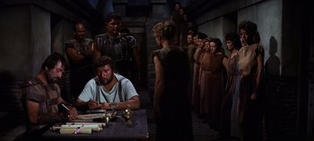 Movie still from “Spartacus” (1960), directed by Stanley Kubrick – A group of people standing around a table; Medium shot, High angle