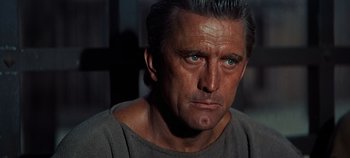 Movie still from “Spartacus” (1960), directed by Stanley Kubrick – A person wearing a gray shirt; Close Up shot, Over the shoulder angle