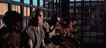 Movie still from “Spartacus” (1960), directed by Stanley Kubrick – A group of men sitting next to each other eating food; Medium shot, High angle