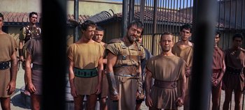 Movie still from “Spartacus” (1960), directed by Stanley Kubrick – A group of men standing next to each other; Medium shot, Low angle