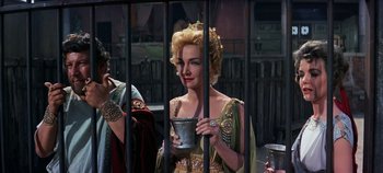 Movie still from “Spartacus” (1960), directed by Stanley Kubrick – A woman holding a silver bowl in a cage; Medium shot, Over the shoulder angle