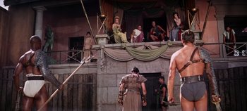 Movie still from “Spartacus” (1960), directed by Stanley Kubrick – A group of people sitting and standing on top of a building; Wide shot, Low angle