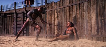 Movie still from “Spartacus” (1960), directed by Stanley Kubrick – Two men are fighting in the sand on a beach; Wide shot, Low angle