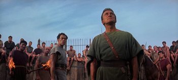 Movie still from “Spartacus” (1960), directed by Stanley Kubrick – A group of men standing next to each other on top of a fence; Medium shot, Low angle
