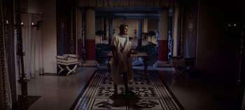 Movie still from “Spartacus” (1960), directed by Stanley Kubrick – A man dressed in toga stands in a room with columns; Wide shot, High angle