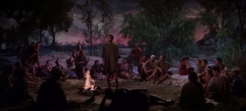 Movie still from “Spartacus” (1960), directed by Stanley Kubrick – A group of people sitting around a fire; Wide shot, High angle