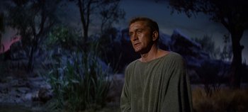 Movie still from “Spartacus” (1960), directed by Stanley Kubrick – A man standing in front of some trees; Medium shot, Low angle