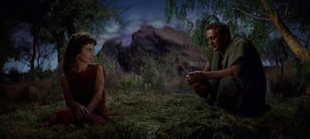 Movie still from “Spartacus” (1960), directed by Stanley Kubrick – A man kneeling down next to a woman in a field; Medium shot, High angle