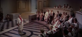 Movie still from “Spartacus” (1960), directed by Stanley Kubrick – A group of men in robes sitting in a room; Extreme Wide shot, High angle