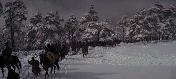 Movie still from “Spartacus” (1960), directed by Stanley Kubrick – A group of people riding horses through a snowy forest; Extreme Wide shot, High angle