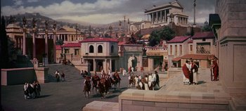 Movie still from “Spartacus” (1960), directed by Stanley Kubrick – People are riding horses on a city street; Extreme Wide shot, High angle