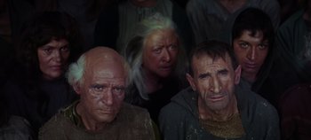 Movie still from “Spartacus” (1960), directed by Stanley Kubrick – Two men and a woman are sitting in a room; Medium shot, High angle