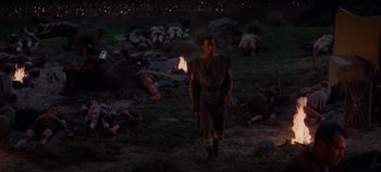 Movie still from “Spartacus” (1960), directed by Stanley Kubrick – A man walking in a field at night with a stick; Wide shot, High angle