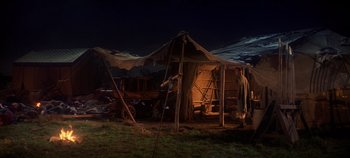 Movie still from “Spartacus” (1960), directed by Stanley Kubrick – A man standing in front of a tent in the dark; Extreme Wide shot, High angle